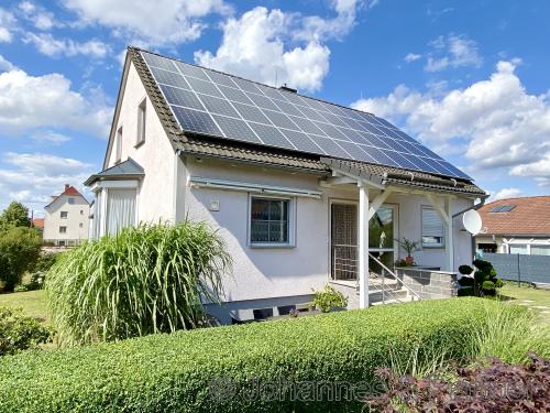 seitliche Hausansicht mit Photovoltaik-Anlage auf dem Dach